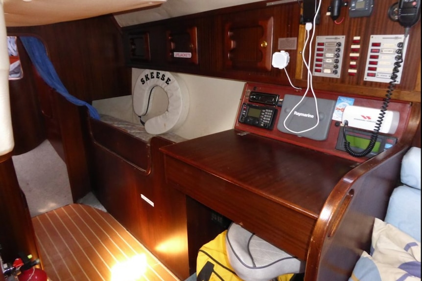 Interior of yacht desk and radio area with life horseshoe with Skeese on it.