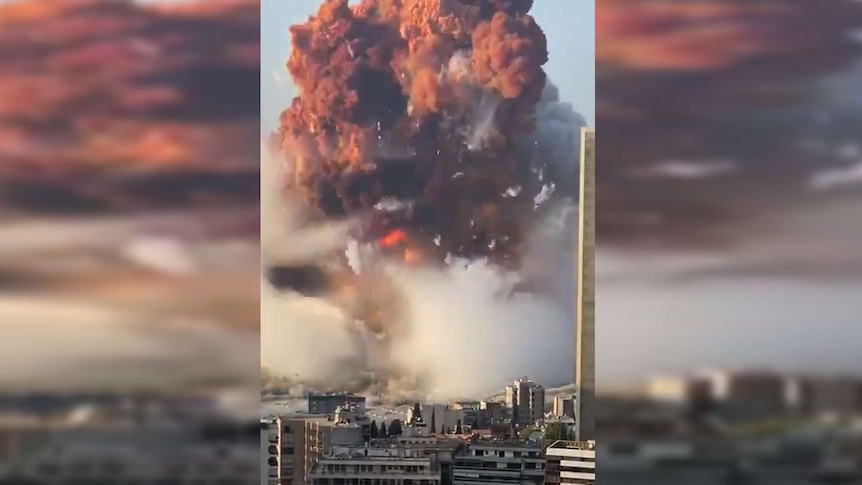 A huge explosion at a port creates a cloud of debris many times higher than tall apartment buildings.