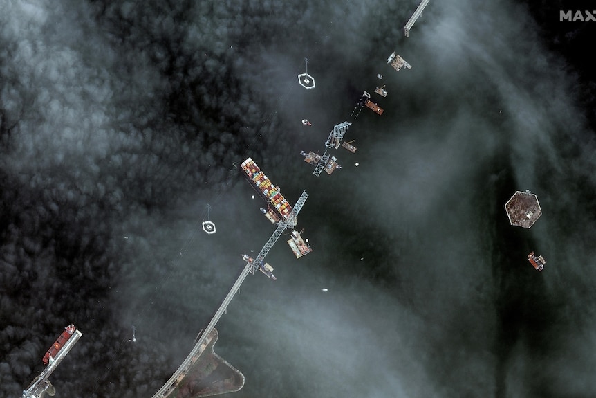 A satellite image of the bridge broken into pieces around the container ship