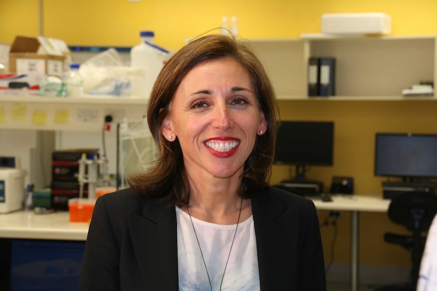 Dianna Magliano stands in the middle of a laboratory.