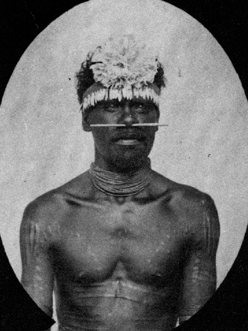 A black and white photo from the 1880s of a tribal looking man.
