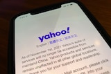 A smart phone shows a statement from Yahoo which says it is exiting China.