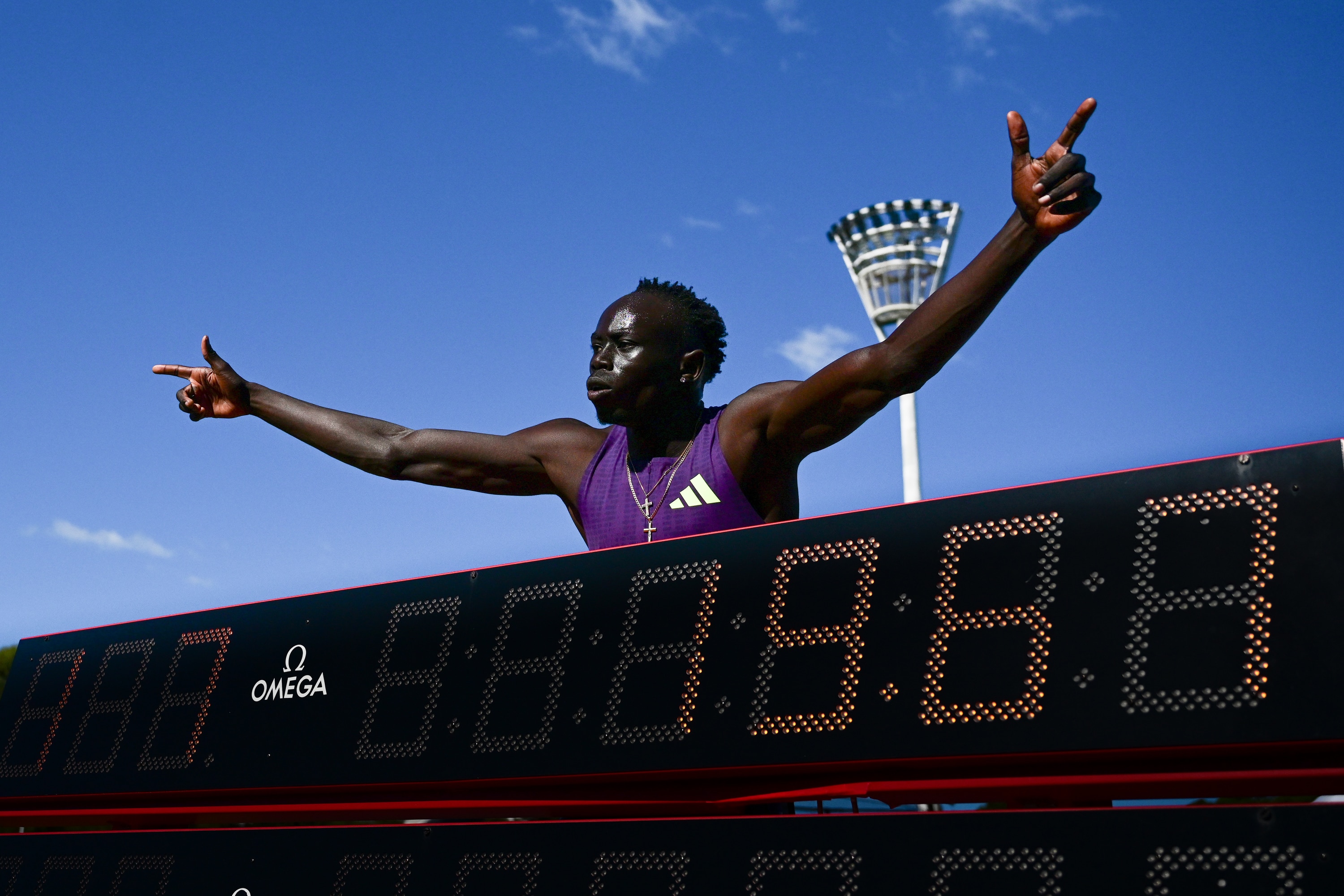 Gout Gout celebrates with the official time board after winning 200m at Australian Athletics Championships.