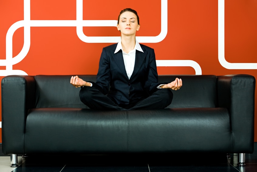 Woman on black lounge in meditation pose