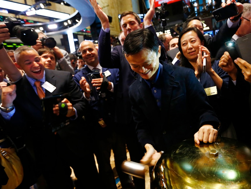 Alibaba Group Holding Ltd founder Jack Ma (C) rings a ceremonial bell in Wall Street. 