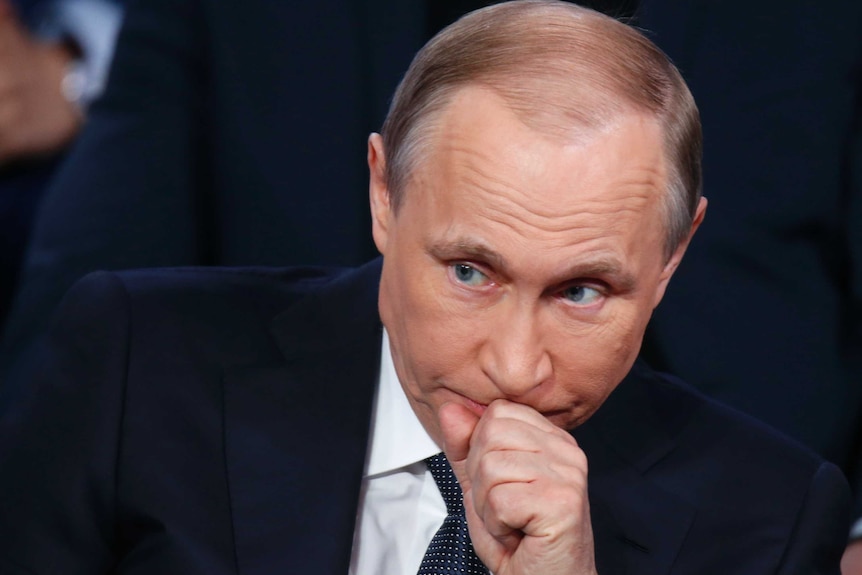 Close-up of Russian President Vladimir Putin sitting down.