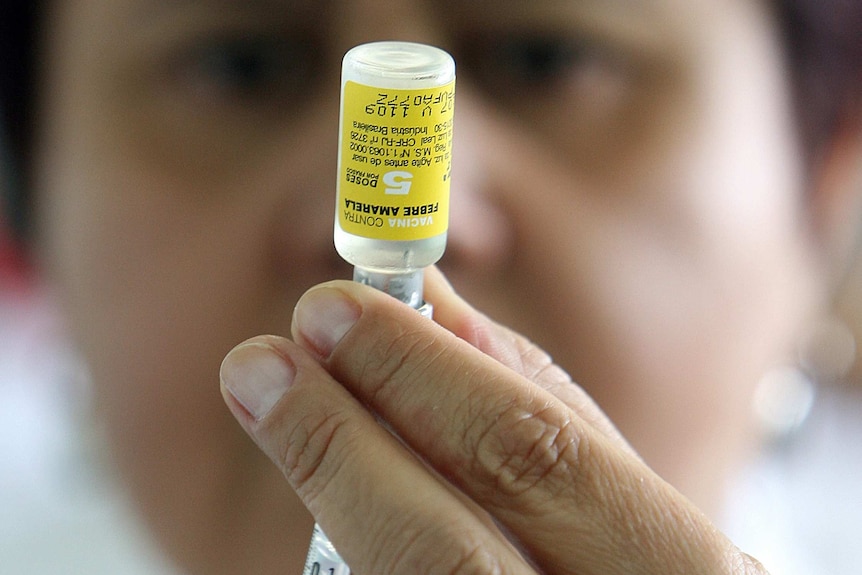 A nurse prepares a yellow fever vaccine