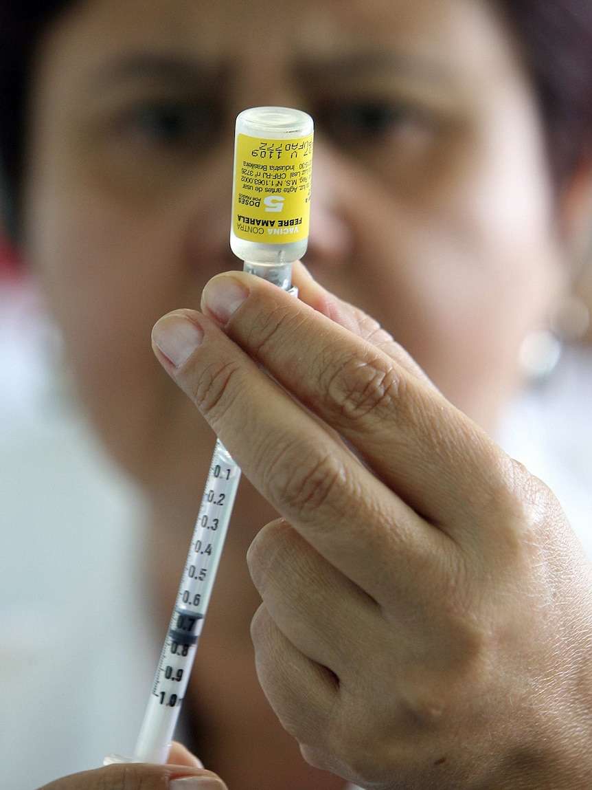 A nurse prepares a yellow fever vaccine