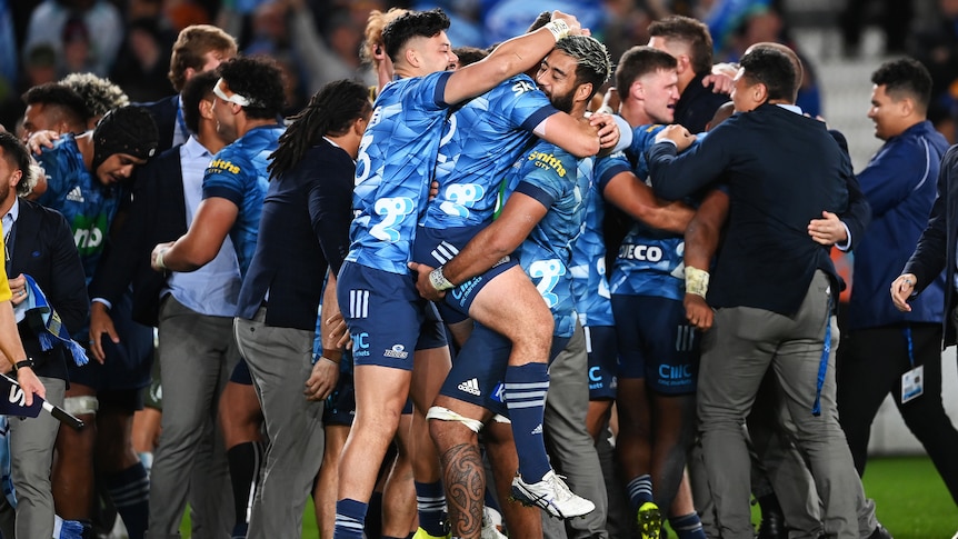 Three Blues Super Rugby trans-Tasman players embrace after beating the Highlanders.