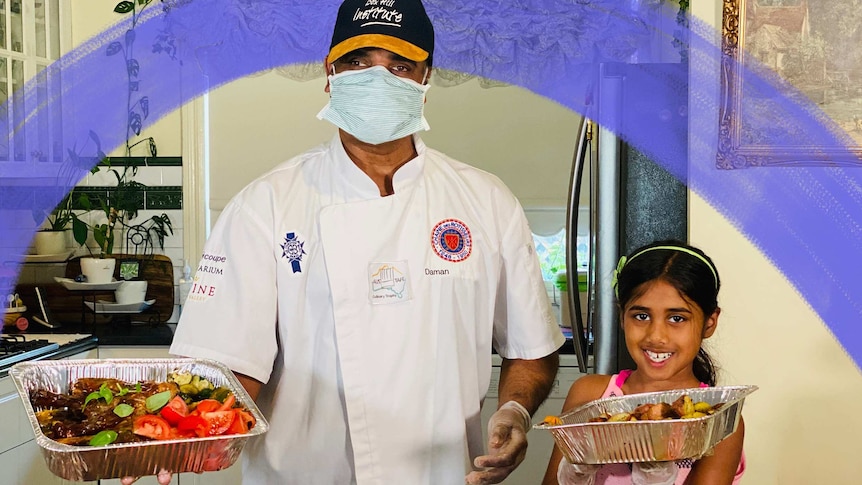 Daman and Diya smile while holding trays of food, for a story about their  charity during Melbourne's lockdown.