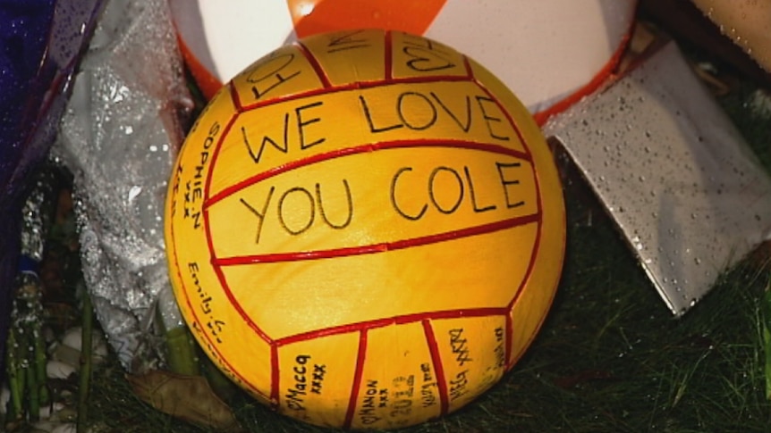 A water polo ball left at a floral tribute site for Cole Miller