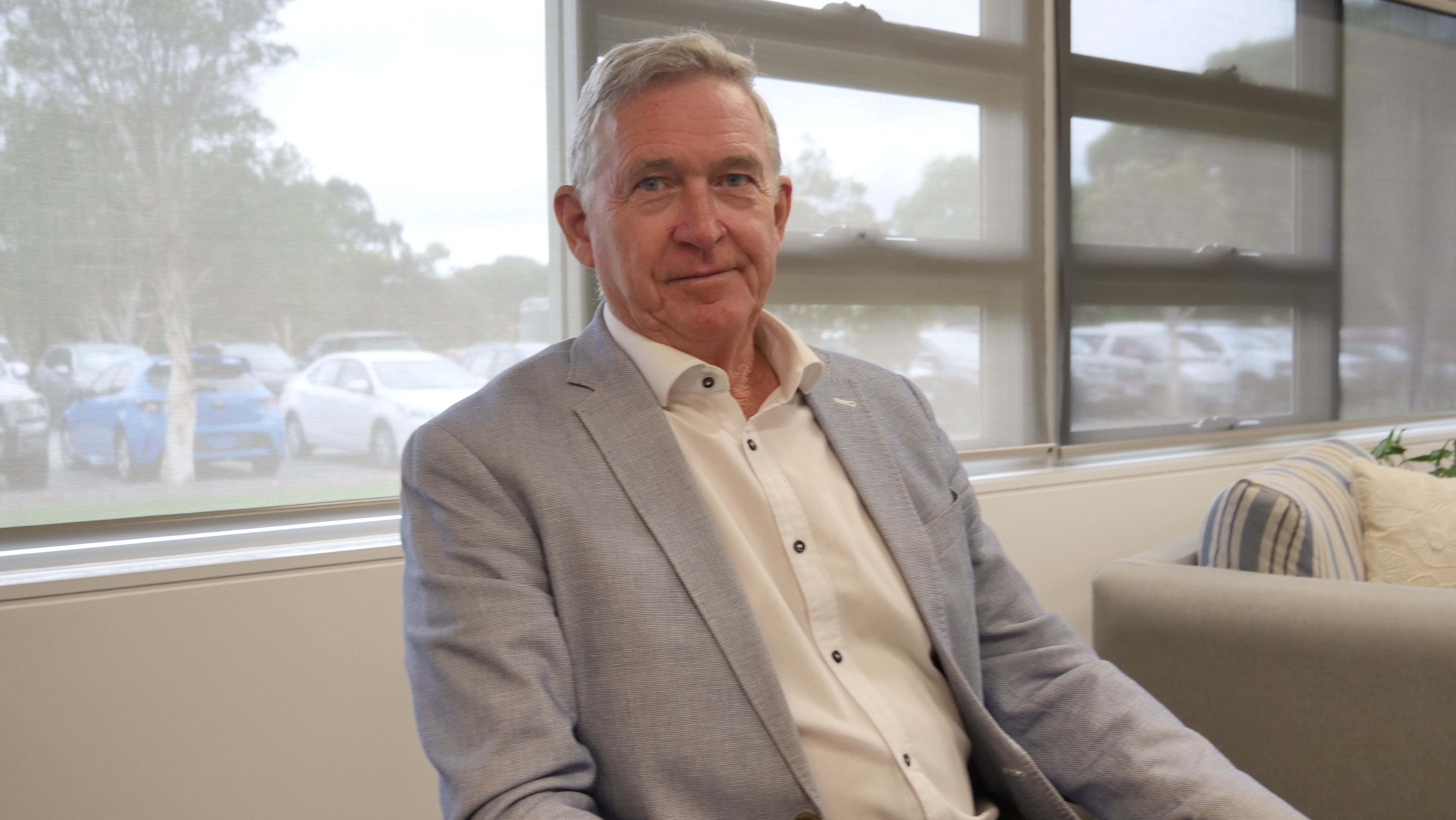 Plano medio de un hombre con traje gris.