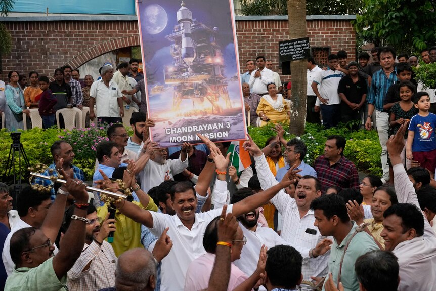 People celebrate as they watch a live telecast of the moon landing in India. 