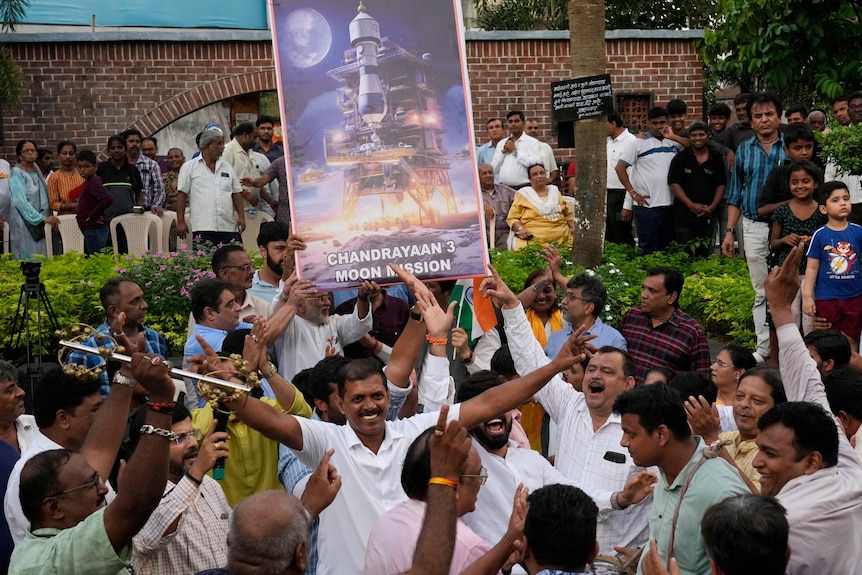 People celebrate as they watch a live telecast of the moon landing in India. 