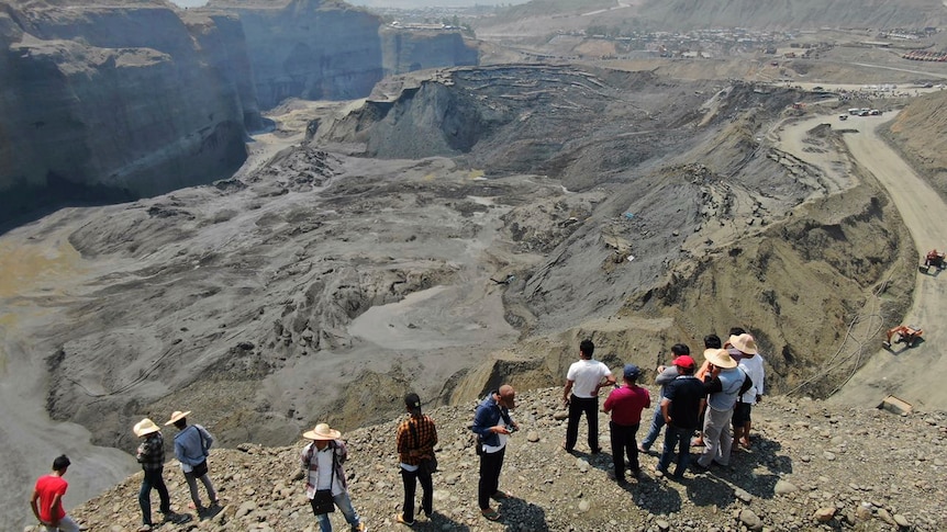 Onlookers observe a UN sanctioned mining site in Hpakant area of Kachin state, northern Myanmar
