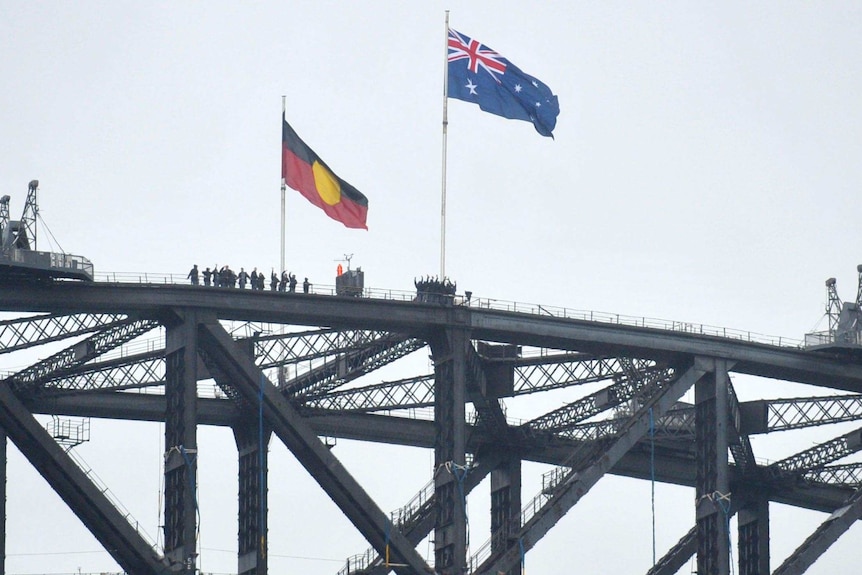 The Australian and Aboriginal flags fly on top of the Sydney Harbour Bridge.