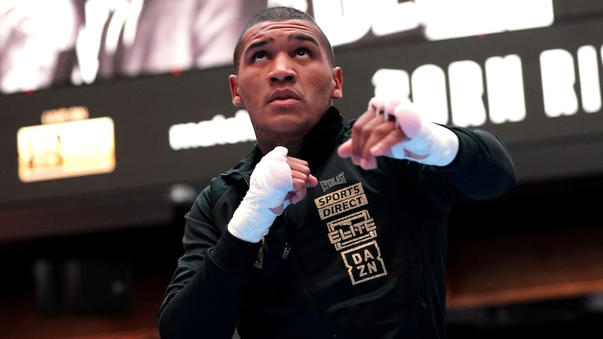 Boxer Conor Benn shadow boxes while wearing hand wraps.