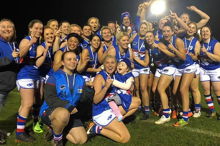 A female football team poses for a photo.