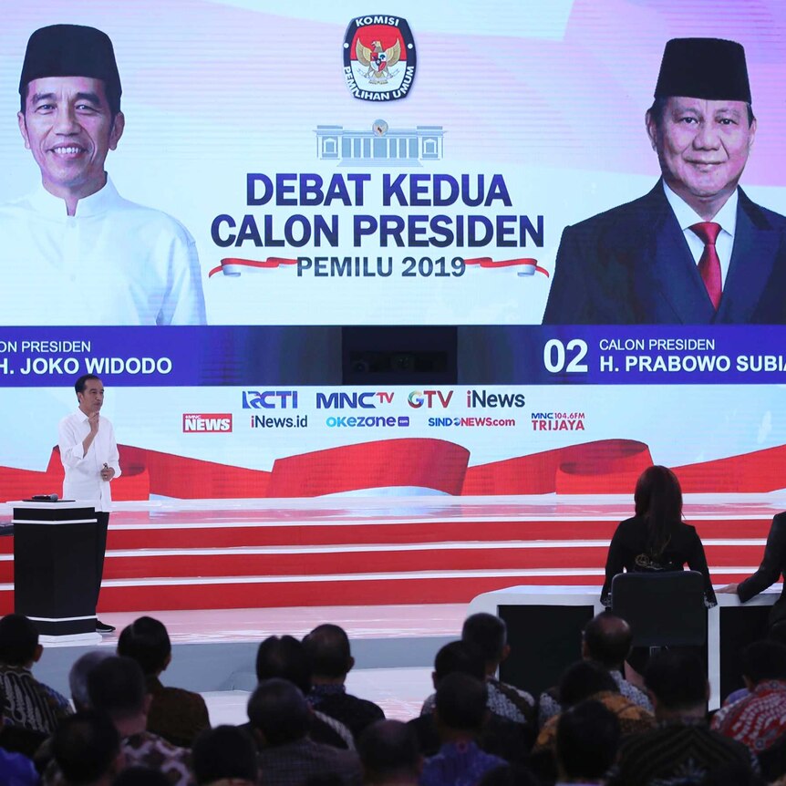 Indonesian presidential election candidates walk onto the stage.