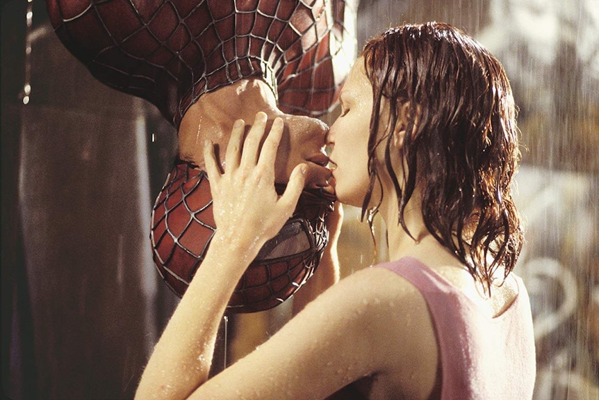 Kirsten Dunst kisses an upside-down Tobey Maguire (spider-man) in the rain