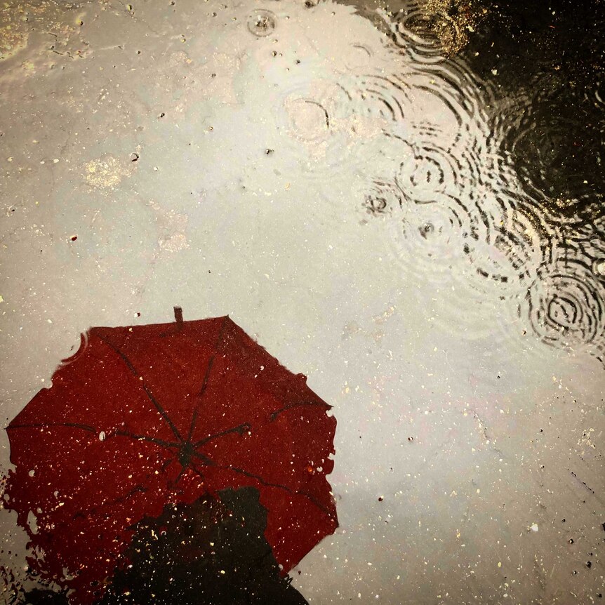 Reflection of a red umbrella in the rain