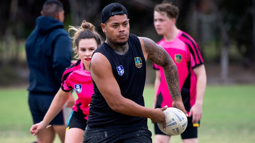 Halatau Tuima (C) rugby League player for the Eastern Raptors runs with the ball while training with other players.
