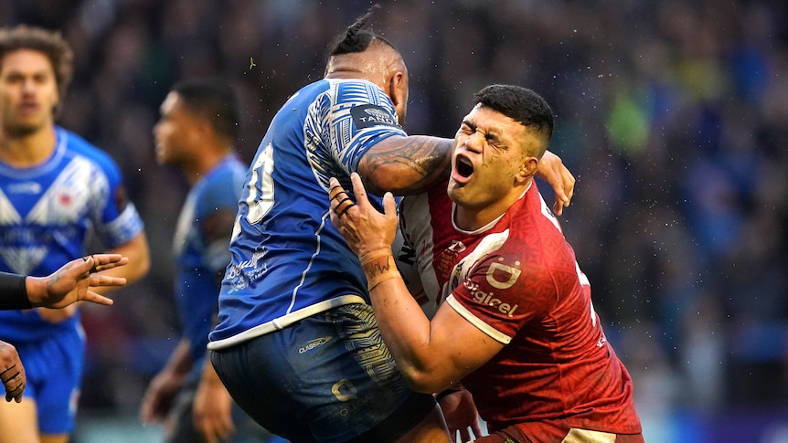 Tonga's David Fifita shouts in pain as he tries to tackle Samoa's Junior Paulo at the Rugby League World Cup.