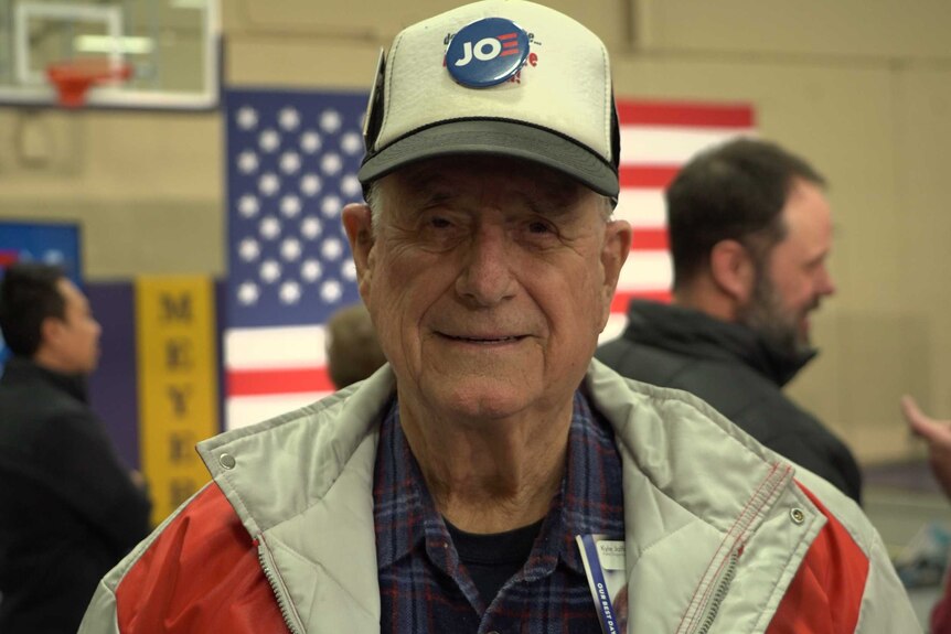 A man in a cap with a 'Joe' button attached to the front