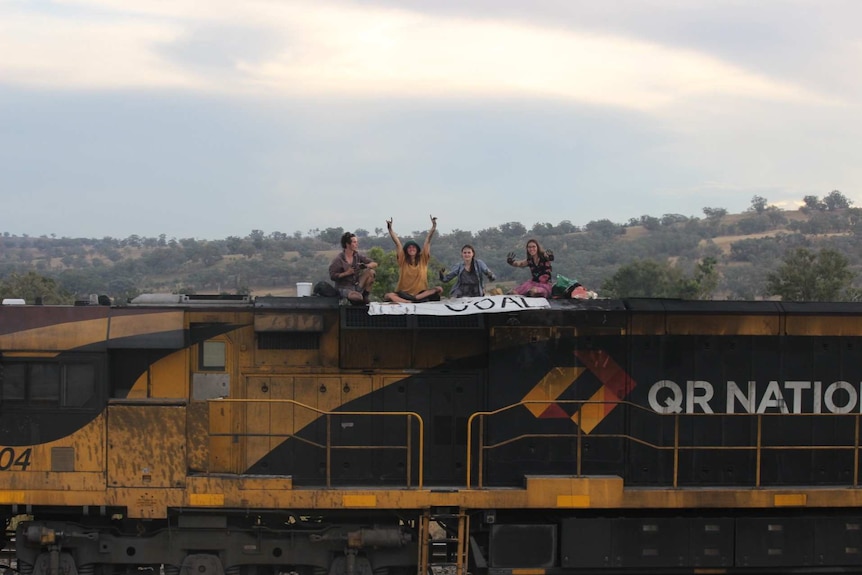 Four people sitting on a train on a coal mine