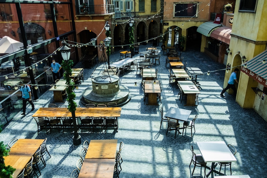 empty outdoor restaurant with empty table and chairs