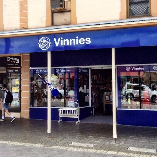 vinnies retail shop front with blue signage glass windows and a porch  and paved walkway