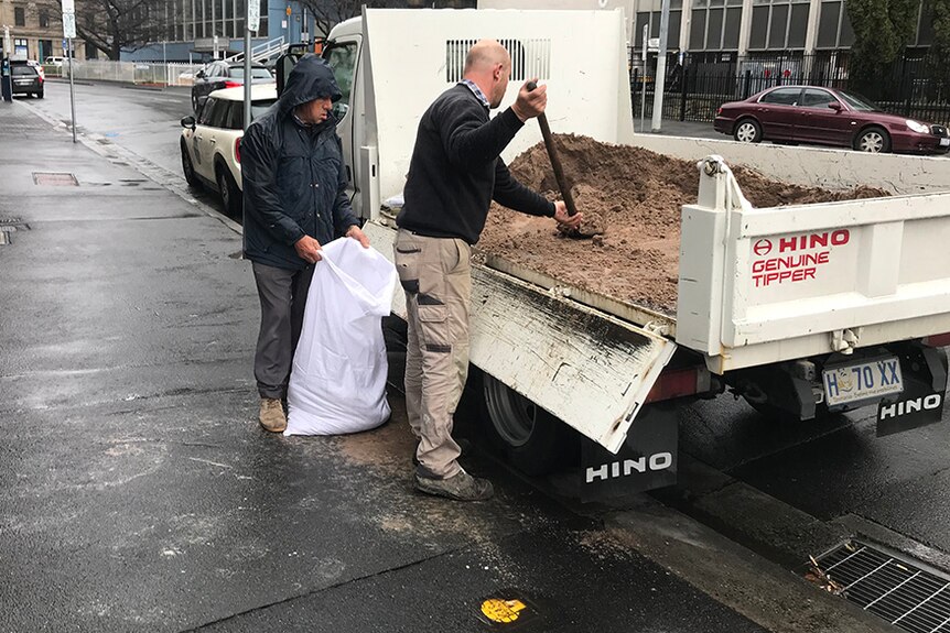 People fill sandbags in central Hobart