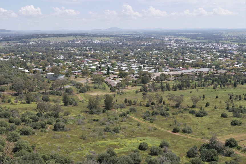 an aerial shot of a town surrounded by green paddocks