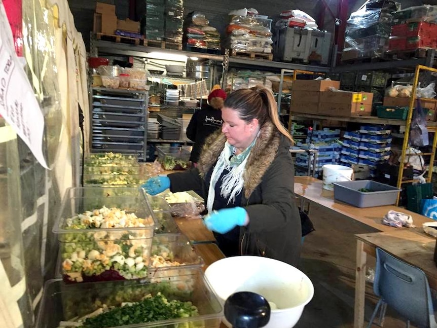 Megan Hanna works in a very basic kitchen, surrounded by produce.