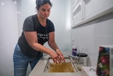 A woman standing over a sink washing her hands