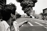 A man points towards a burning car in Beijing on June 4, 1989, the day of the Tiananmen Square massacre.