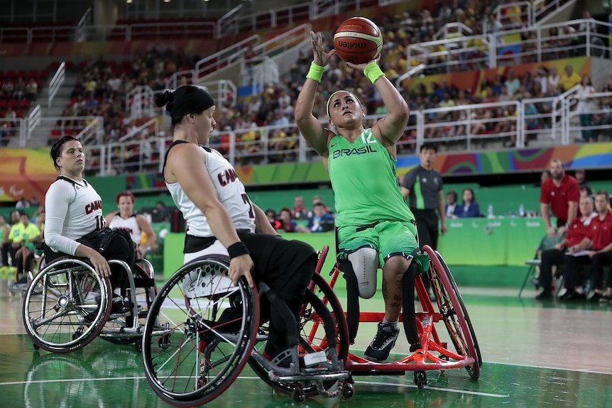 A female wheelchair basketball player palms the ball ready to shoot for a basket for Brazil at the Paralympics.