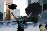 在2014年的亲民主抗议活动中，一名示威者面对防暴警察发射出的催泪瓦斯举起雨伞。