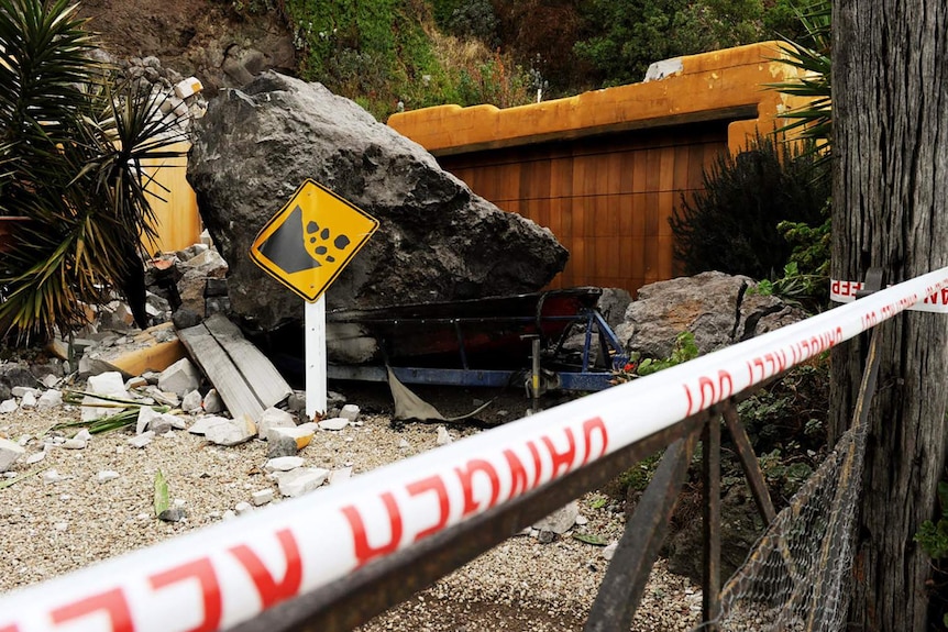 Hammered: a broken sign sits near a cliffside residence at Redcliff