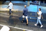Three men with their backs to the camera on CCTV footage.