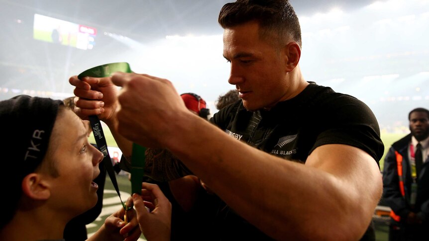 Heart-warming moment ... Sonny Bill Williams hands his winners' medal to a young spectator at Twickenham
