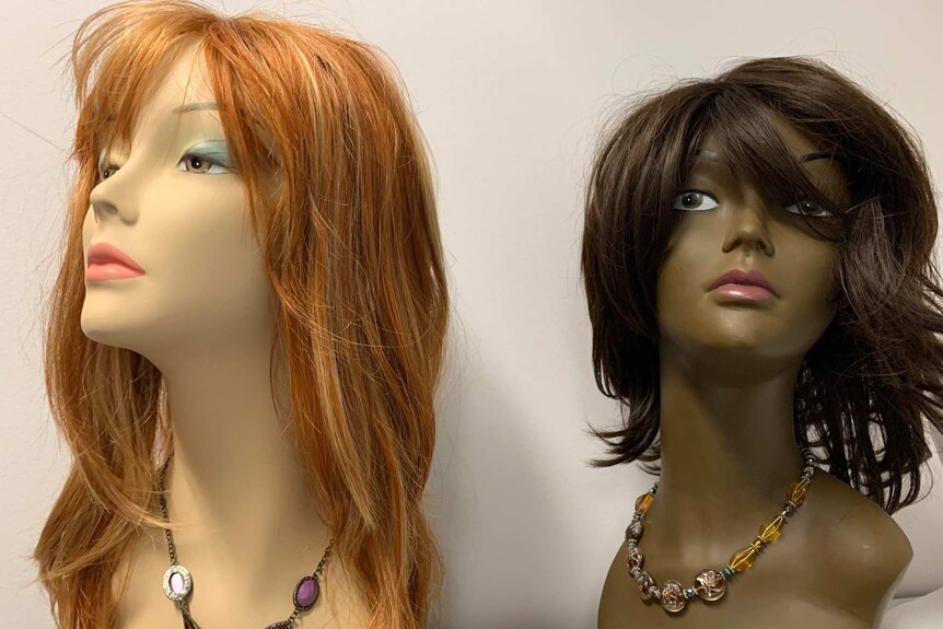 Two manikins wearing wigs.