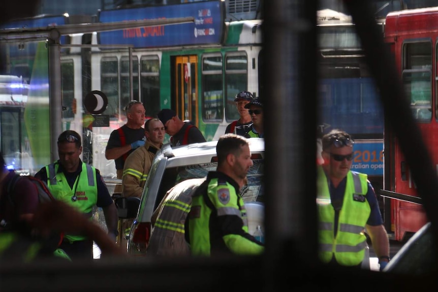 Emergency services gather around a car that ran through a pedestrian crossing.