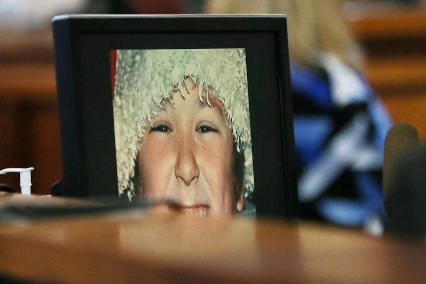 A close up of a photo frame with a smiling white boy in it.