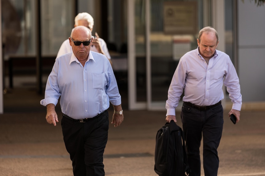 Two men walking out of a courthouse.  