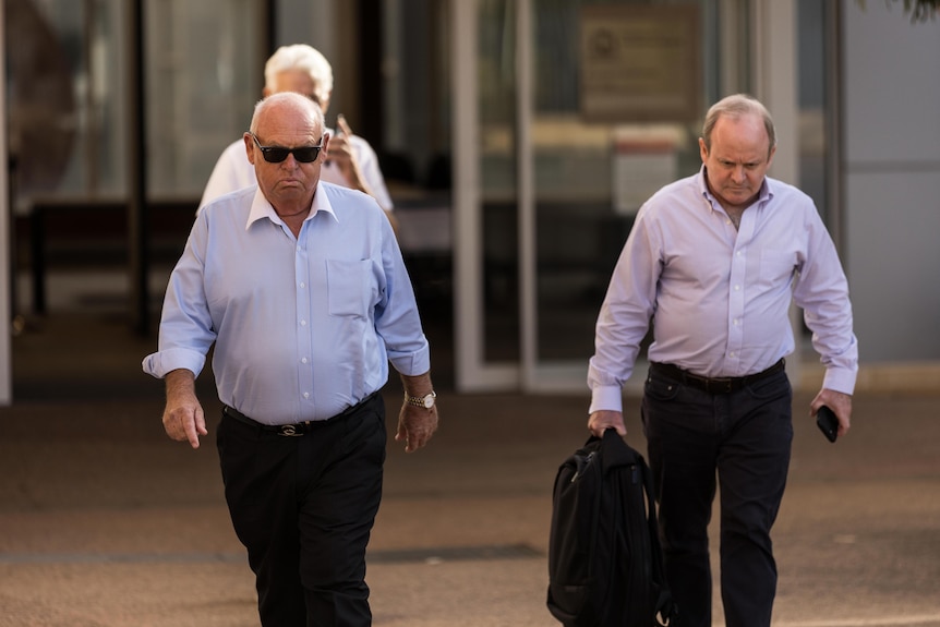 Two men walking out of a courthouse.