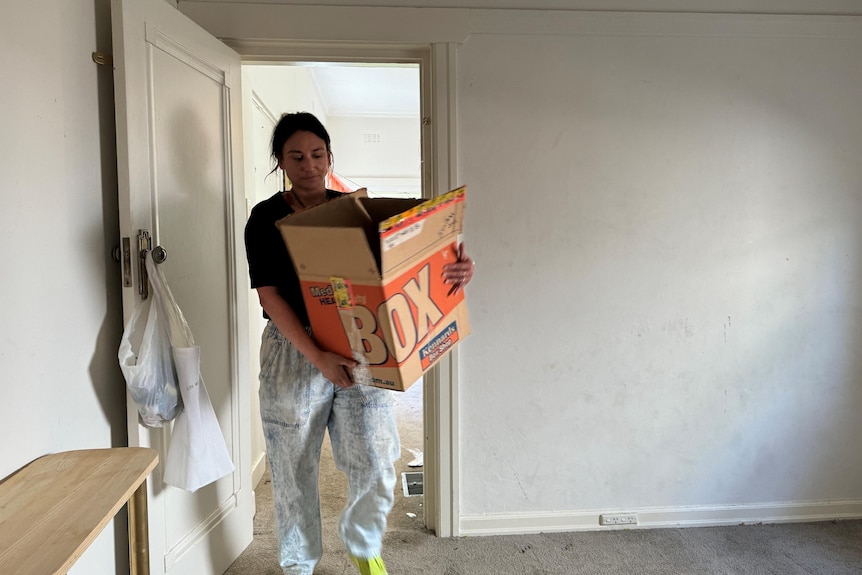 a woman holding moving boxes