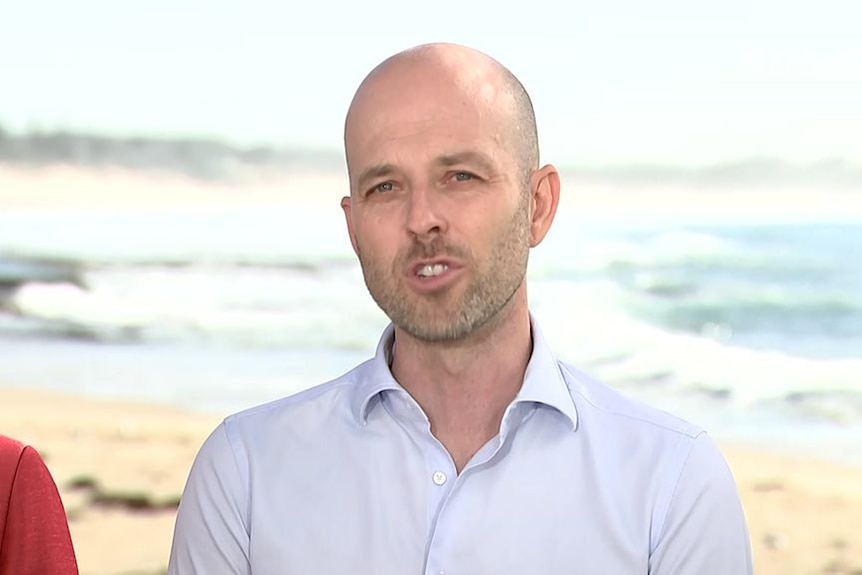 Liberal candidate for Cook Simon Kennedy holds a press conference at the beach.