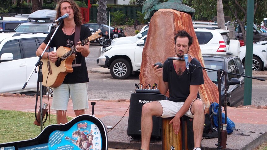 Melbourne musicians George Arnold (l) and Josh Thompson busking to a crowd at Cable Beach in Broome