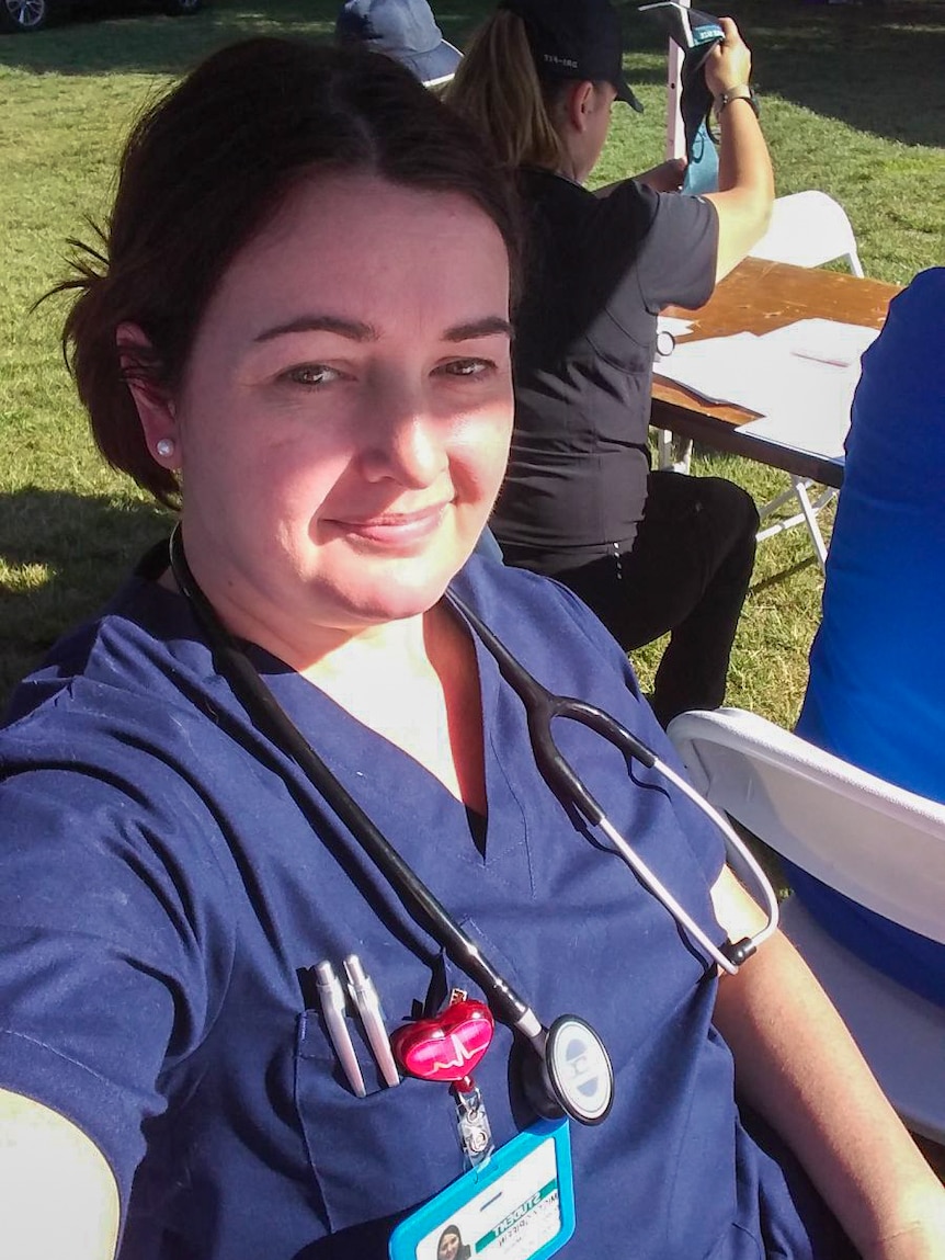 A young brunette woman in scrubs